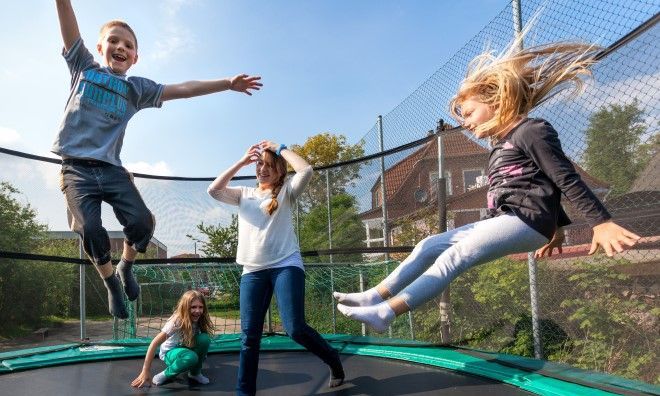 Freiwillige (FSJ) mit Kindern auf einem Trampolin