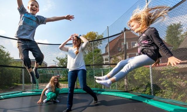 Freiwillige (FSJ) mit Kindern auf einem Trampolin